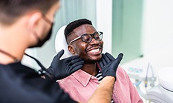 Dentist looking at patient's smile in treatment room