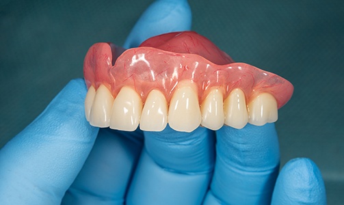 Dentist holding dentures