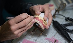 Lab technician filing dentures