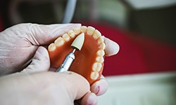 Lab technician filing dentures