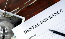 Dental insurance form with pen and dental X ray