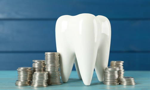 Model of tooth surrounded by stacks of coins