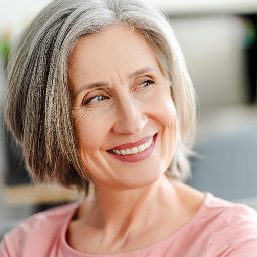 Older woman smiling thanks to zirconia dental implants