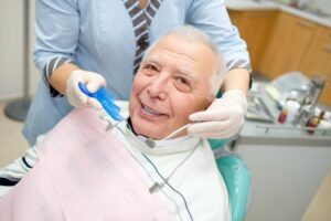 smiling older man with dentures having a dental checkup
