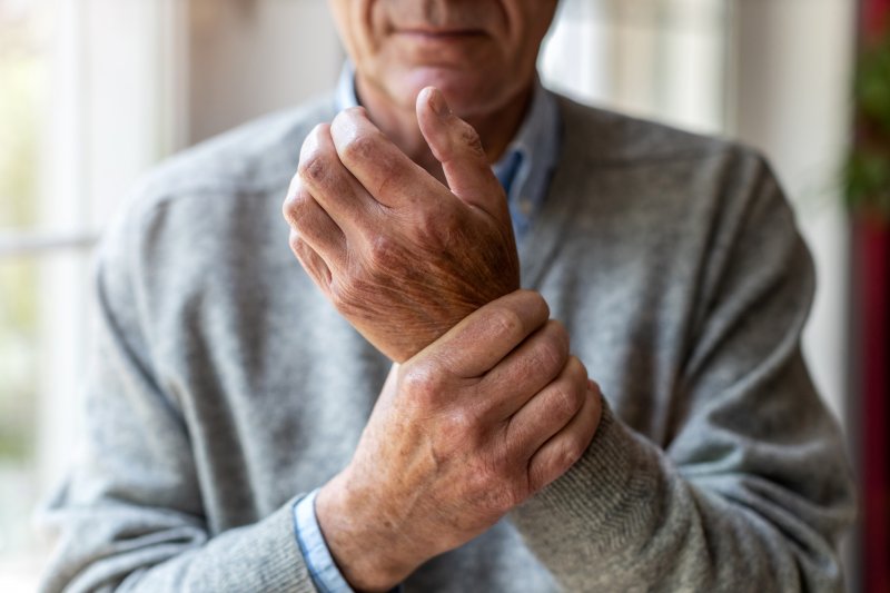 A senior man rubbing his arthritic hands